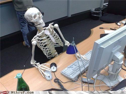 A skeleton waits at a computer.